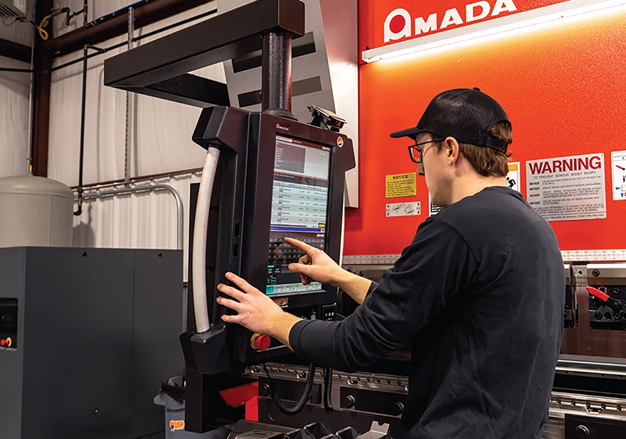 Technician interacting with an AMADA machine control screen