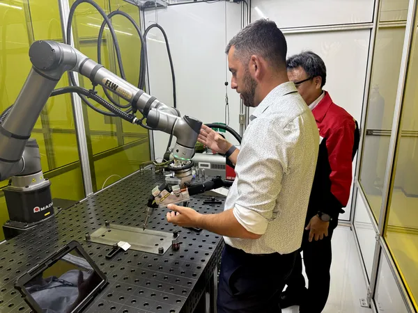 Application engineer demonstrating the collaborative robot welding cell